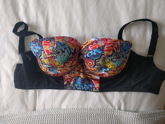 The Graffiti laid out on a bed, the front of the bra is visible.